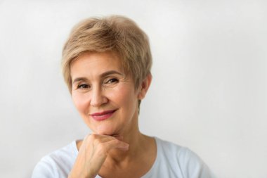 beyaz bir arka plan üzerinde kısa saç kesimi ile şık güzel yaşlı kadın