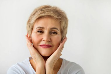 beyaz bir arka plan üzerinde kısa saç kesimi ile şık güzel yaşlı kadın
