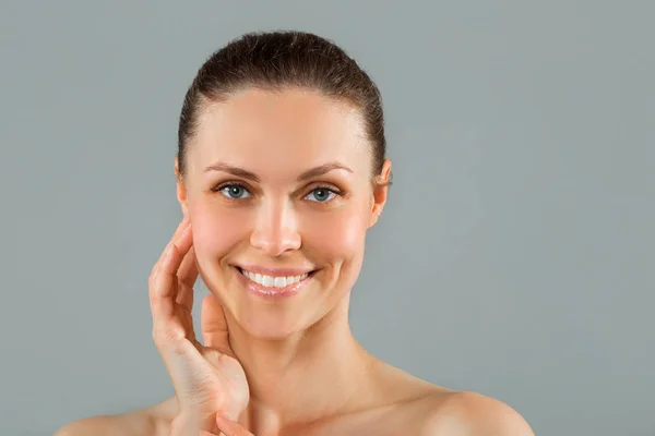 mavi bir arka plan üzerinde bir gülümseme ile güzel genç kadın