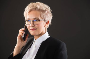 gözlük şık yaşlı kadın ve siyah ceket telefonla arıyor