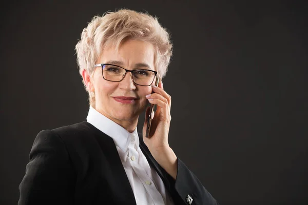 Stijlvolle Oudere Vrouw Glazen Een Zwarte Jas Belt Telefonisch — Stockfoto