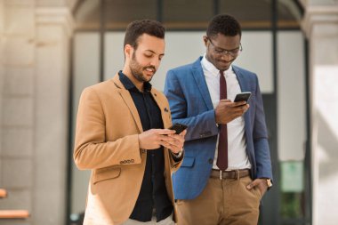 elinde telefonları ile takım elbiseli iki adam