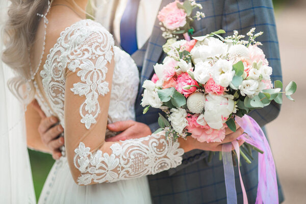 beautiful delicate wedding bouquet in the hands of the bride