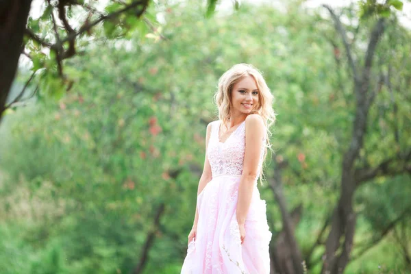 美丽的年轻女子在温柔的粉红色礼服在自然 — 图库照片