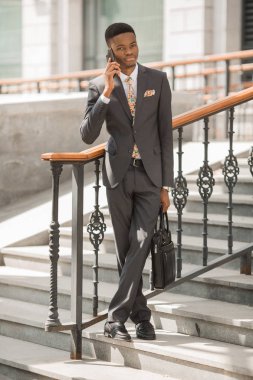 telefonda konuşurken bir takım elbise yakışıklı genç afrikalı adam