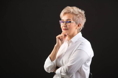 beyaz gömlek ve siyah bir arka plan üzerinde gözlük güzel yaşlı kadın