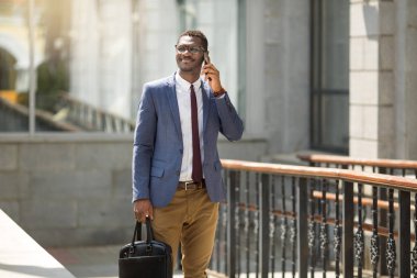takım elbise ve gözlük telefonda konuşurken yakışıklı genç yetişkin Afrikalı adam