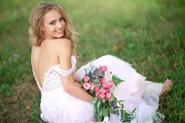 꽃다발과 잔디에 공원에 분홍색 드레스에 메이크업과 아름다운 — 스톡 사진