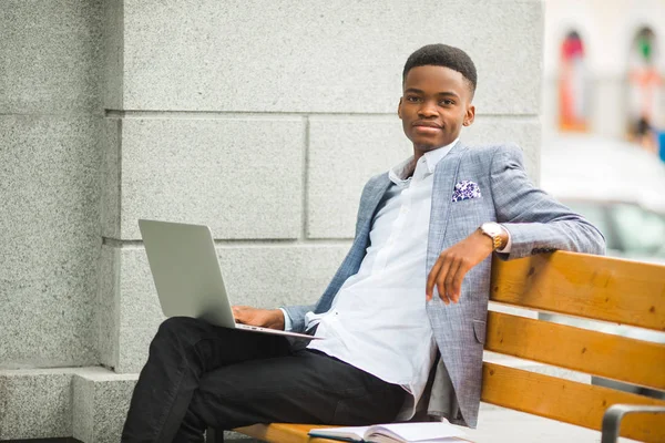 handsome african man in suit with laptop