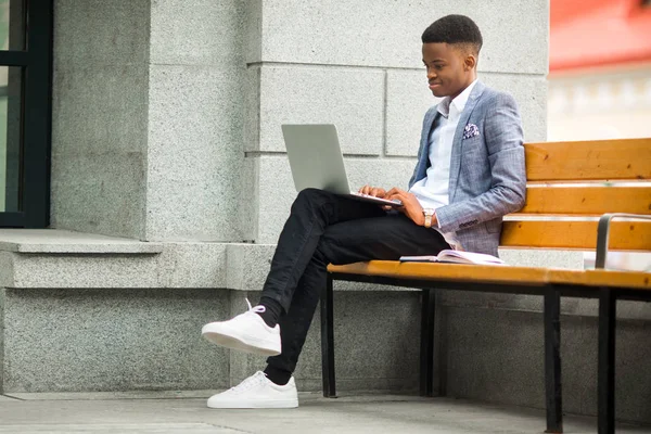 handsome african man in suit with laptop