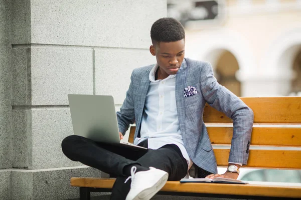 handsome african man in suit with laptop