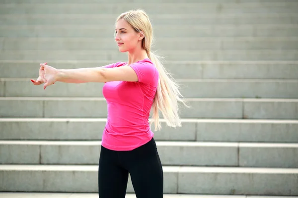 분홍색 티셔츠에 아름다운 여자는 운동을한다 — 스톡 사진