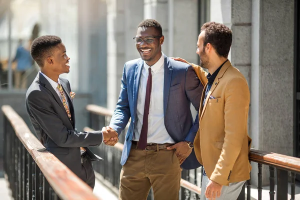 three handsome adult men in suits communicate