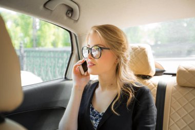 arabada elinde bir telefon ile gözlük güzel bir genç kadının portresi