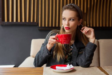 bir fincan kahve ile bir restoranda makyaj ile güzel genç kadın