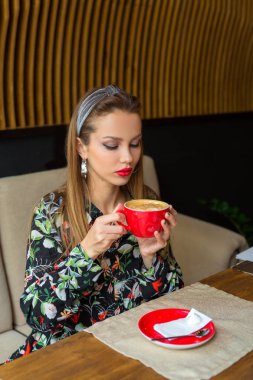 bir fincan kahve ile bir restoranda makyaj ile güzel genç kadın