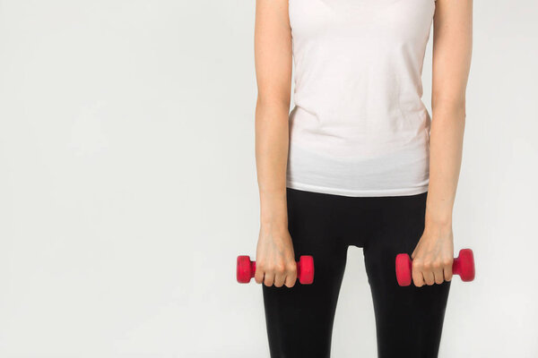 женщина с гантелями в руках на белом фоне
