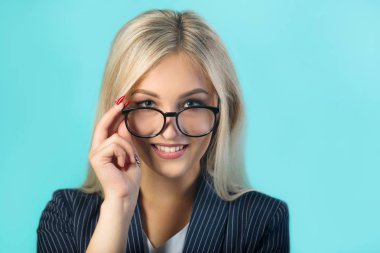 mavi bir arka plan üzerinde gözlük ile siyah takım elbiseli güzel genç kadın