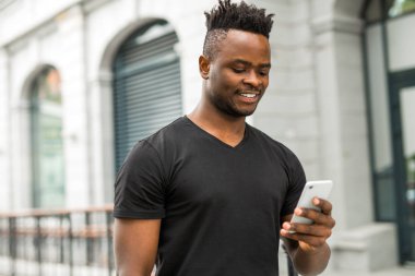 elinde bir telefon ile yakışıklı genç afrikalı adam