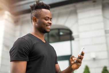 elinde bir telefon ile yakışıklı genç afrikalı adam