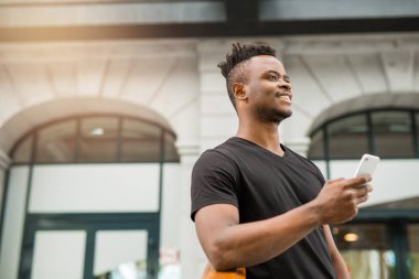 elinde bir telefon ile yakışıklı genç afrikalı adam