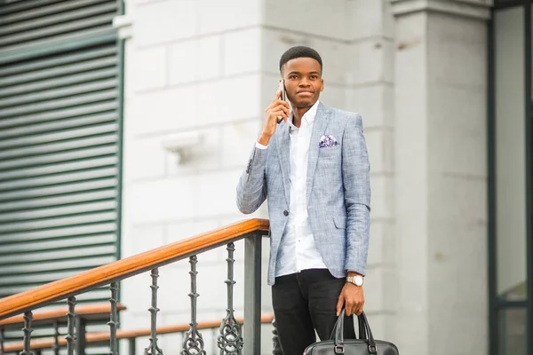 handsome young african man in a suit talking on the phone