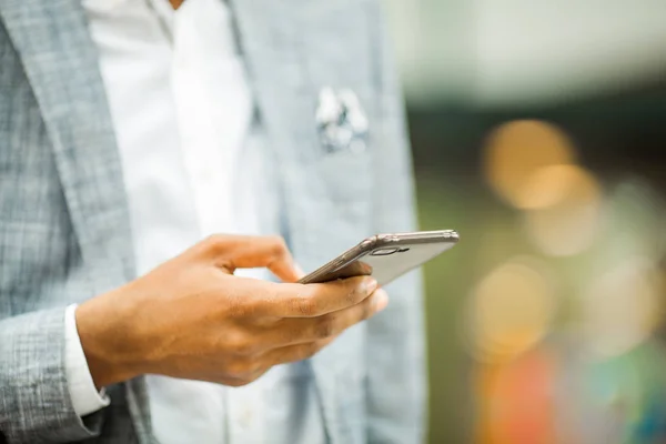 smartphone in hand of african man in suit