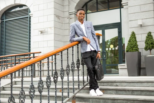 handsome young african man in suit near building