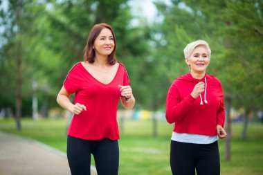  spor giyim iki yetişkin kadın parkta bir yaz çalıştırmak için hazırlanıyor