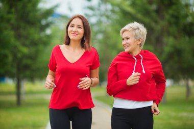  spor giyim iki yetişkin kadın parkta bir yaz çalıştırmak için hazırlanıyor