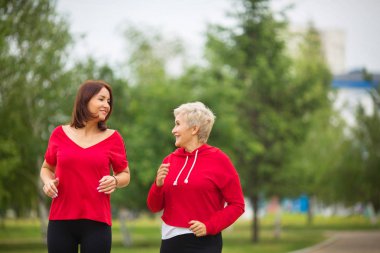  spor giyim iki yetişkin kadın parkta bir yaz çalıştırmak için hazırlanıyor
