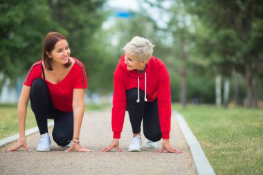  spor giyim iki yetişkin kadın parkta bir yaz çalıştırmak için hazırlanıyor