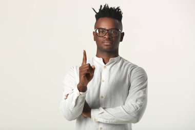 el hareketi ile beyaz arka plan üzerinde gözlük ve beyaz gömlek yakışıklı genç afrikalı adam