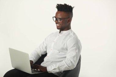 gözlük yakışıklı genç afrikalı adam ve bir dizüstü bilgisayar ile beyaz bir arka plan üzerinde beyaz bir gömlek