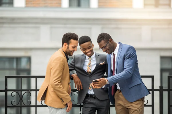 Tres Jóvenes Guapos Trajes Cerca Del Edificio Mira Teléfono —  Fotos de Stock