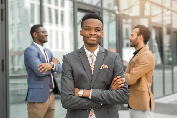 three handsome young men in suits near the building