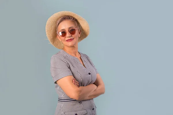 Güneş Gözlüklü Mavi Arka Planda Şapkalı Yaşlı Bir Kadın — Stok fotoğraf