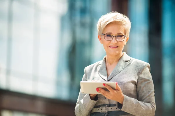 Stylowa Dorosła Kobieta Wieku Garniturze Okularach Tle Szklanego Budynku Tabliczką — Zdjęcie stockowe