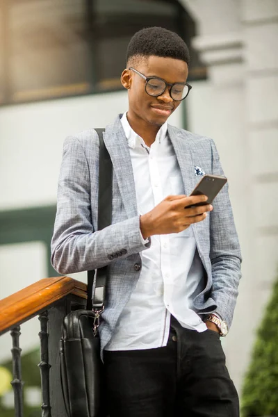 handsome young african man in a suit with a phone in his hand