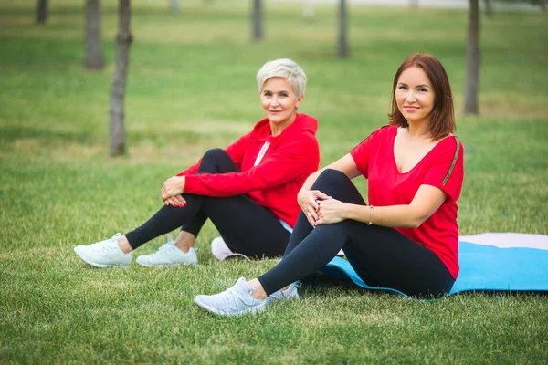 Dos Hermosas Mujeres Adultas Practican Deportes Sentadas Esteras Parque Verano — Foto de Stock