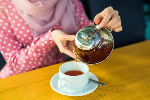 女性はレストランのティーポットにお茶を注ぎ — ストック写真
