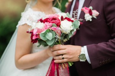 Bir erkek ve bir kadının bir buket çiçekle nazik dokunuşları.