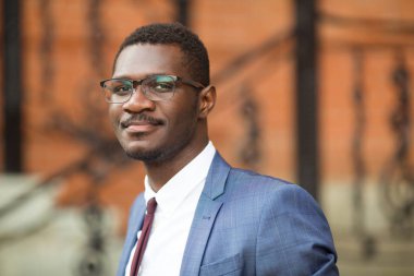 Duvarda gözlüklü yakışıklı bir genç.