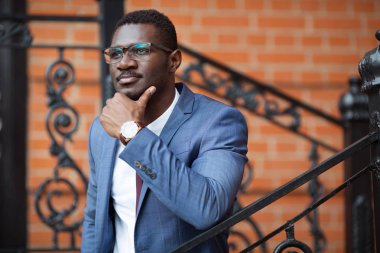 Duvarda gözlüklü yakışıklı bir genç.