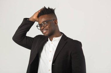 Siyah takım elbiseli yakışıklı Afrikalı genç adam gözlük takıyor.