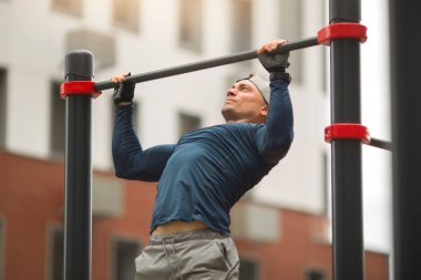  Spor giyimli yakışıklı genç adam dışarıda antrenman yapıyor.