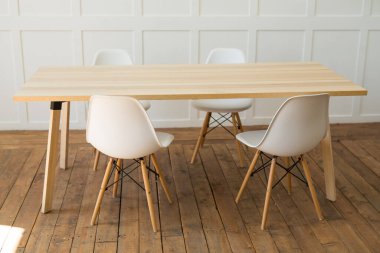 Üç beyaz sandalye ve bir masa.