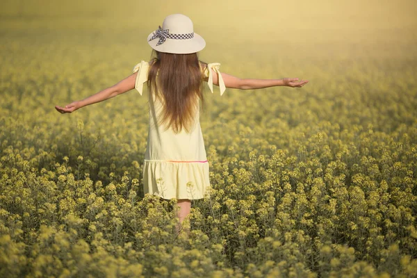 ドレスを着た10代の少女と黄色い畑の帽子 — ストック写真