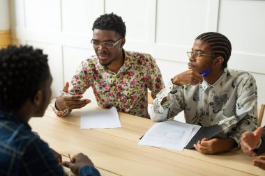 Masadaki ofisteki genç Afrikalı adamlardan oluşan bir ekip.