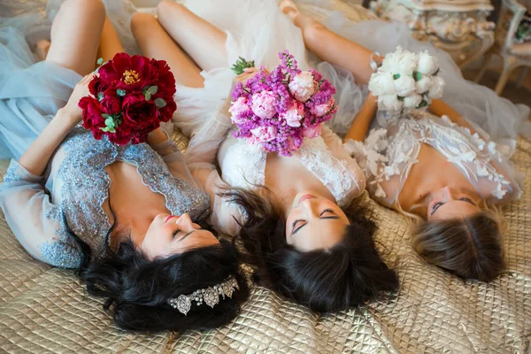 Tres Hermosas Mujeres Vestidos Con Ramos Flores Acostadas Sofá —  Fotos de Stock